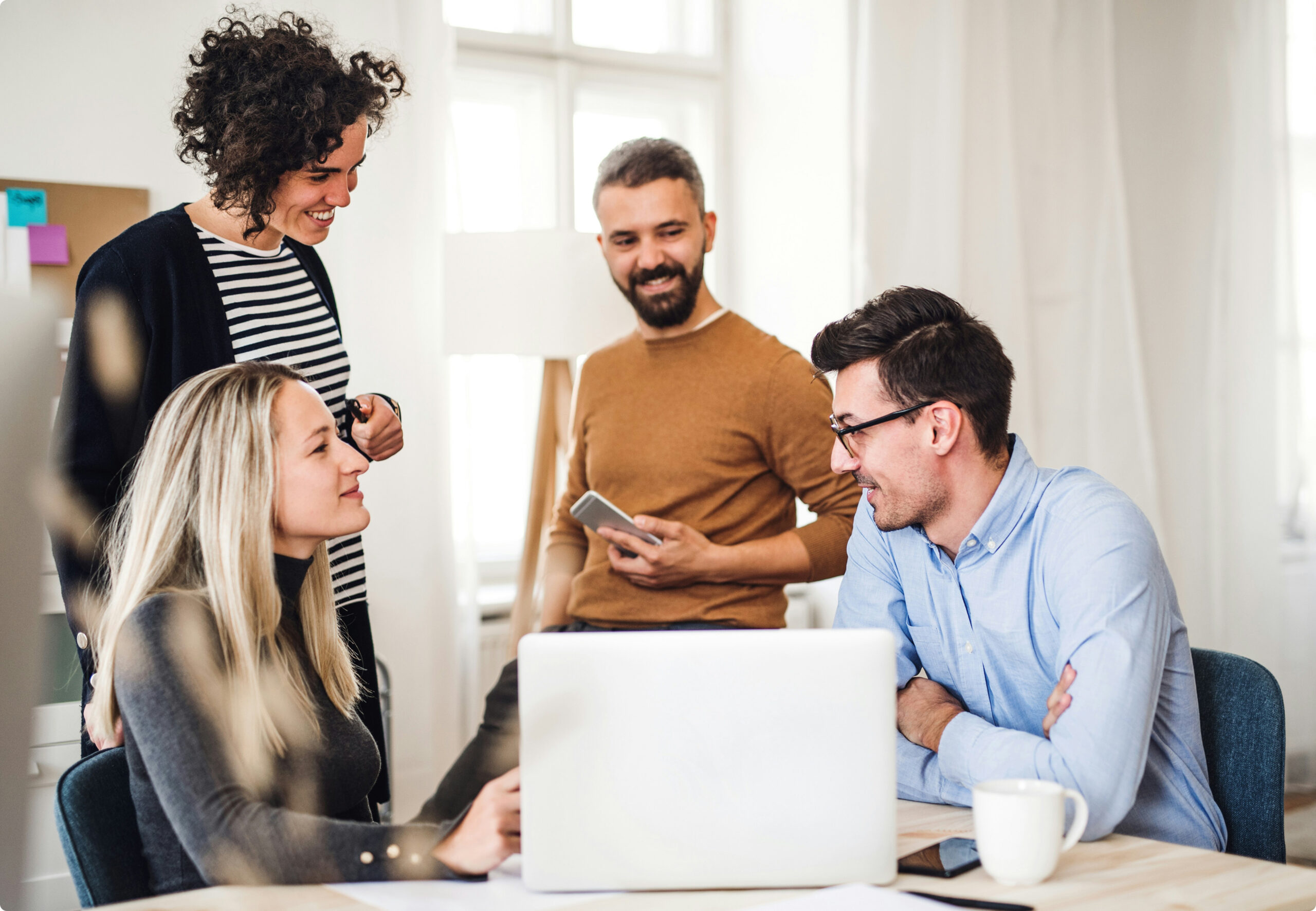 Getty Unsplash — Werkteam dat samenwerkt rond een laptop in een modern kantoor bij Novoffice.