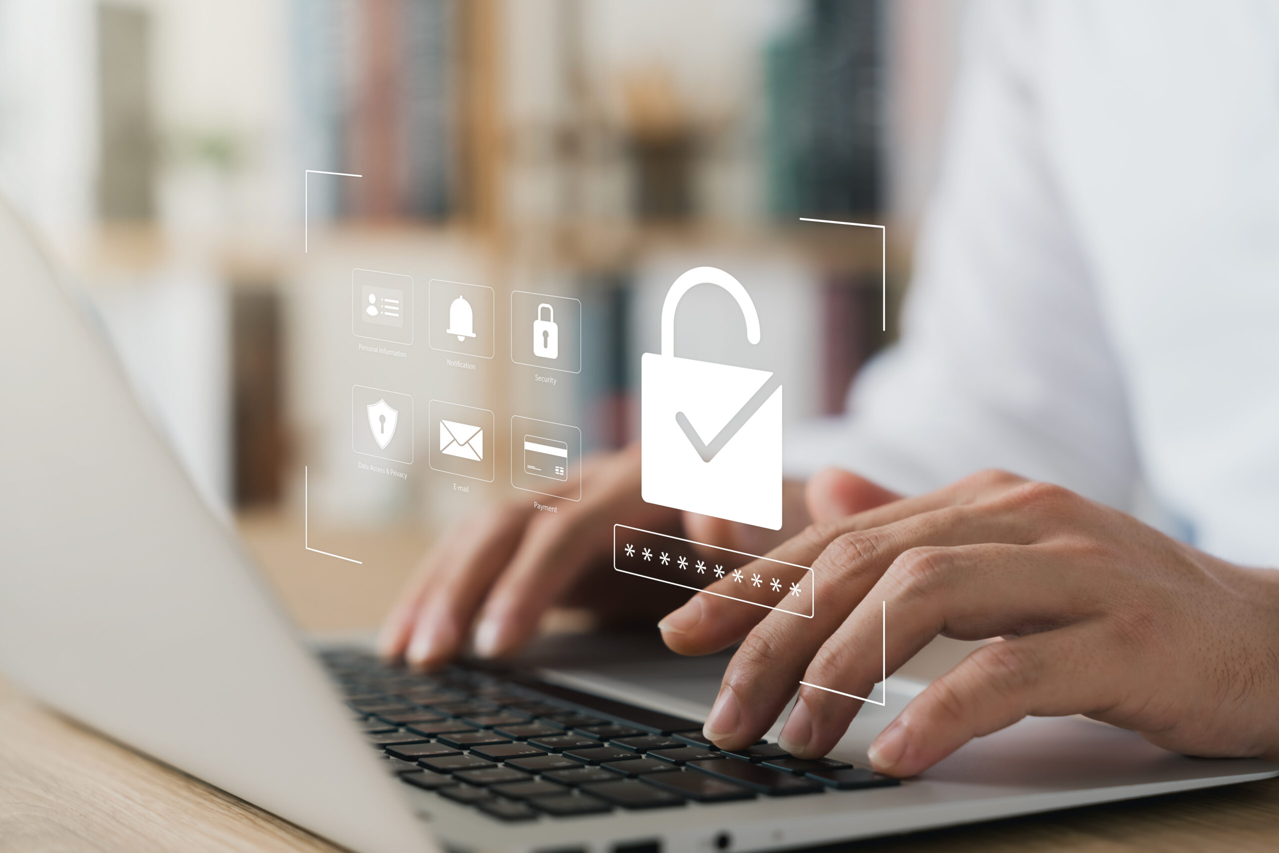 Mains d'une personne tapant sur un clavier d'ordinateur portable avec des icônes de sécurité et un cadenas déverrouillé en surimpression, illustrant…